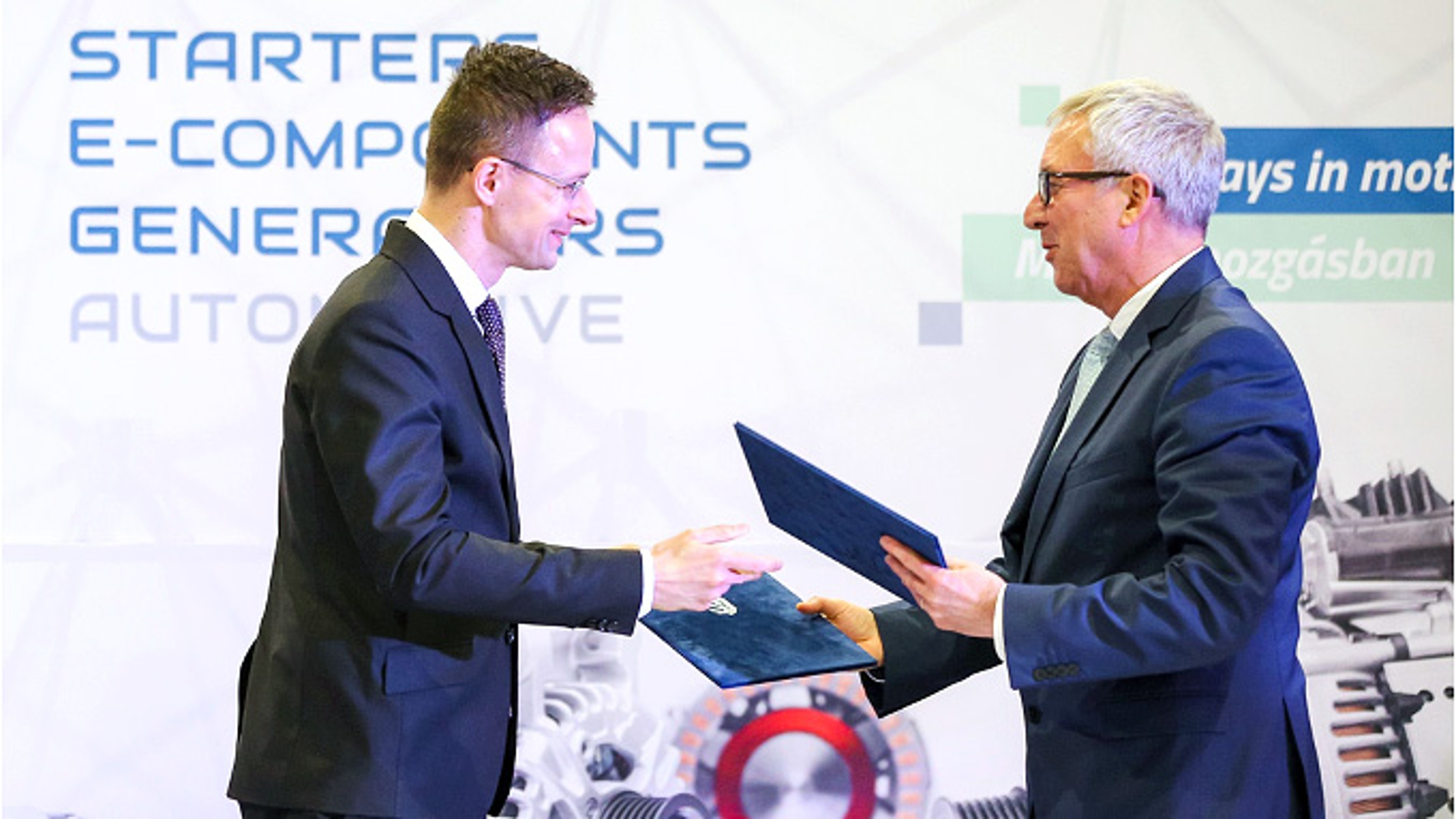 Hungarian Minister Péter Szijjártó and Uwe Mang, SEG Automotive, signing cooperation agreement